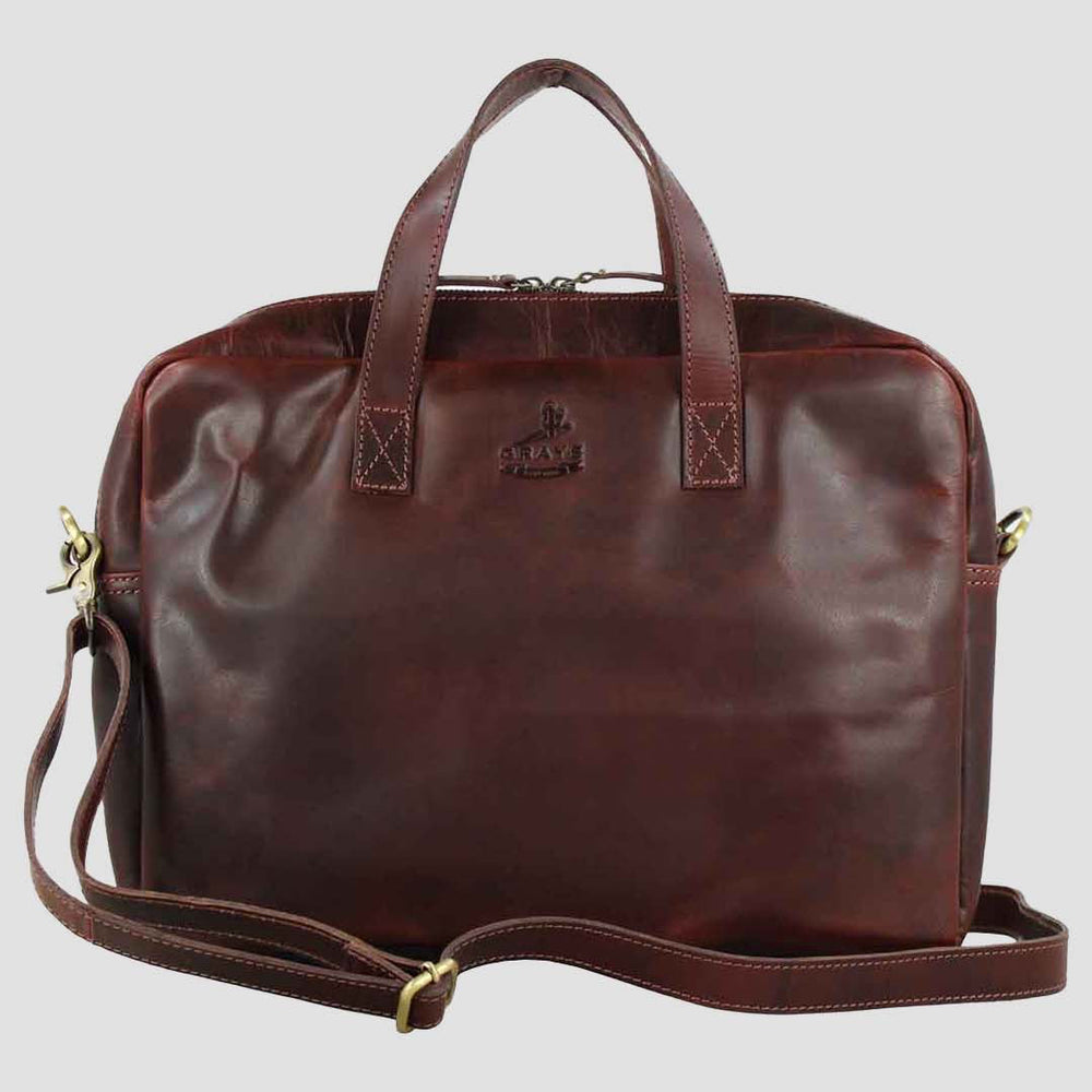 Brown leather bag with gold accents on a light gray background