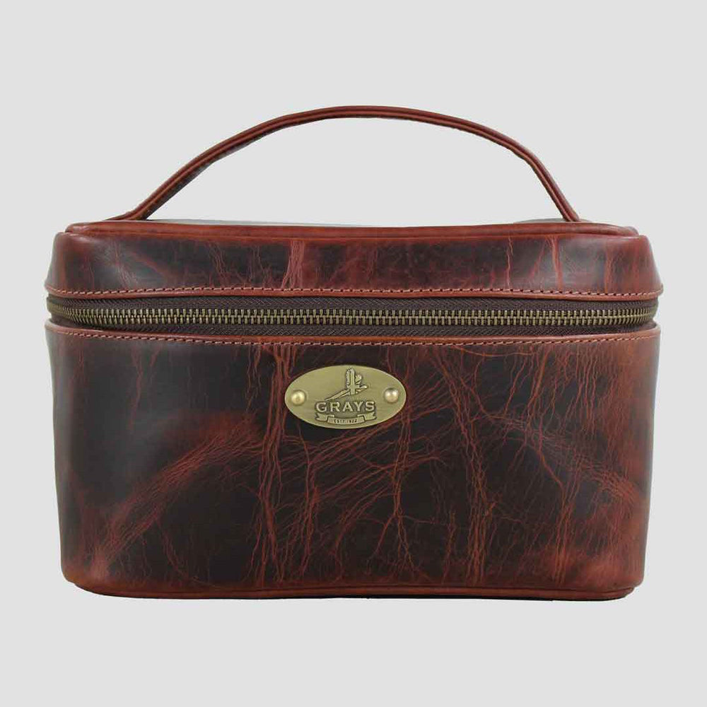 Brown leather travel case with handle on a light gray background