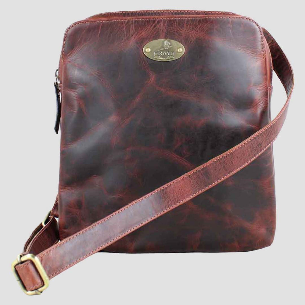 Brown leather crossbody bag with a Grays 1922 brand logo on a light gray background