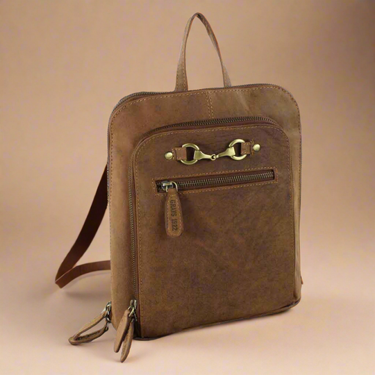 Brown leather backpack with gold zipper pulls on a beige background