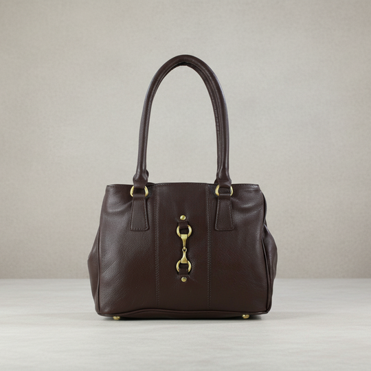 Brown leather handbag with gold hardware on a light gray background