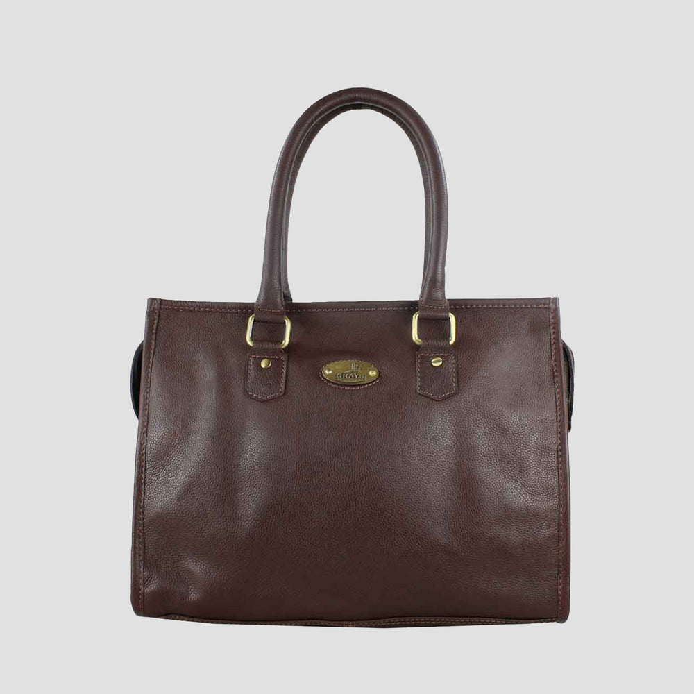 Brown leather handbag with gold hardware on a light gray background